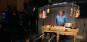 Man in cowboy hat making pizza