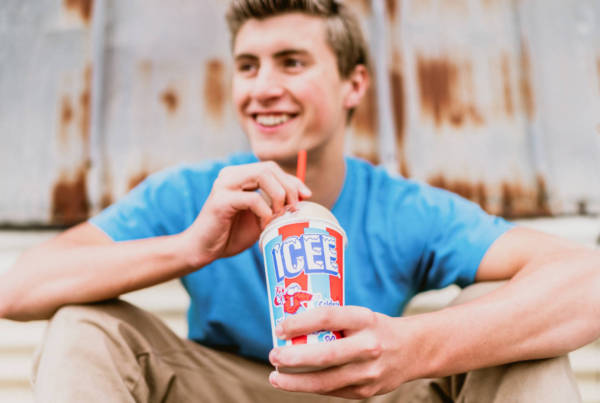 A man smiling drinking an ICEE