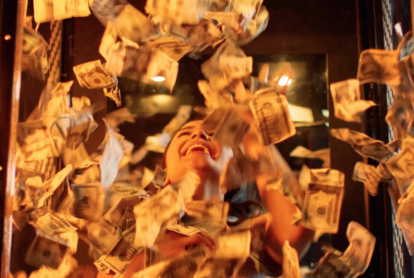 Woman in cube surrounded by flying cash