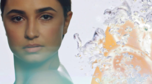 A woman's face next to fruit in water