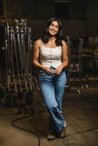 ordan posed confidently in a production studio, surrounded by professional lighting equipment, embodying her role in the video production industry at Windsong Productions.