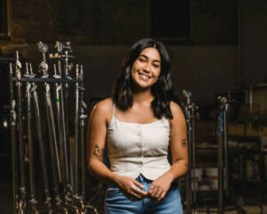 Jordan posed confidently in a production studio, surrounded by professional lighting equipment, embodying her role in the video production industry at Windsong Productions.