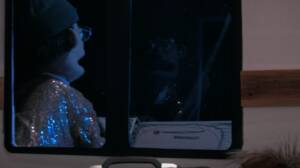Puppet characters seen through a van window at night, wearing sparkly costumes in a whimsical recreation of a Home Alone travel scene